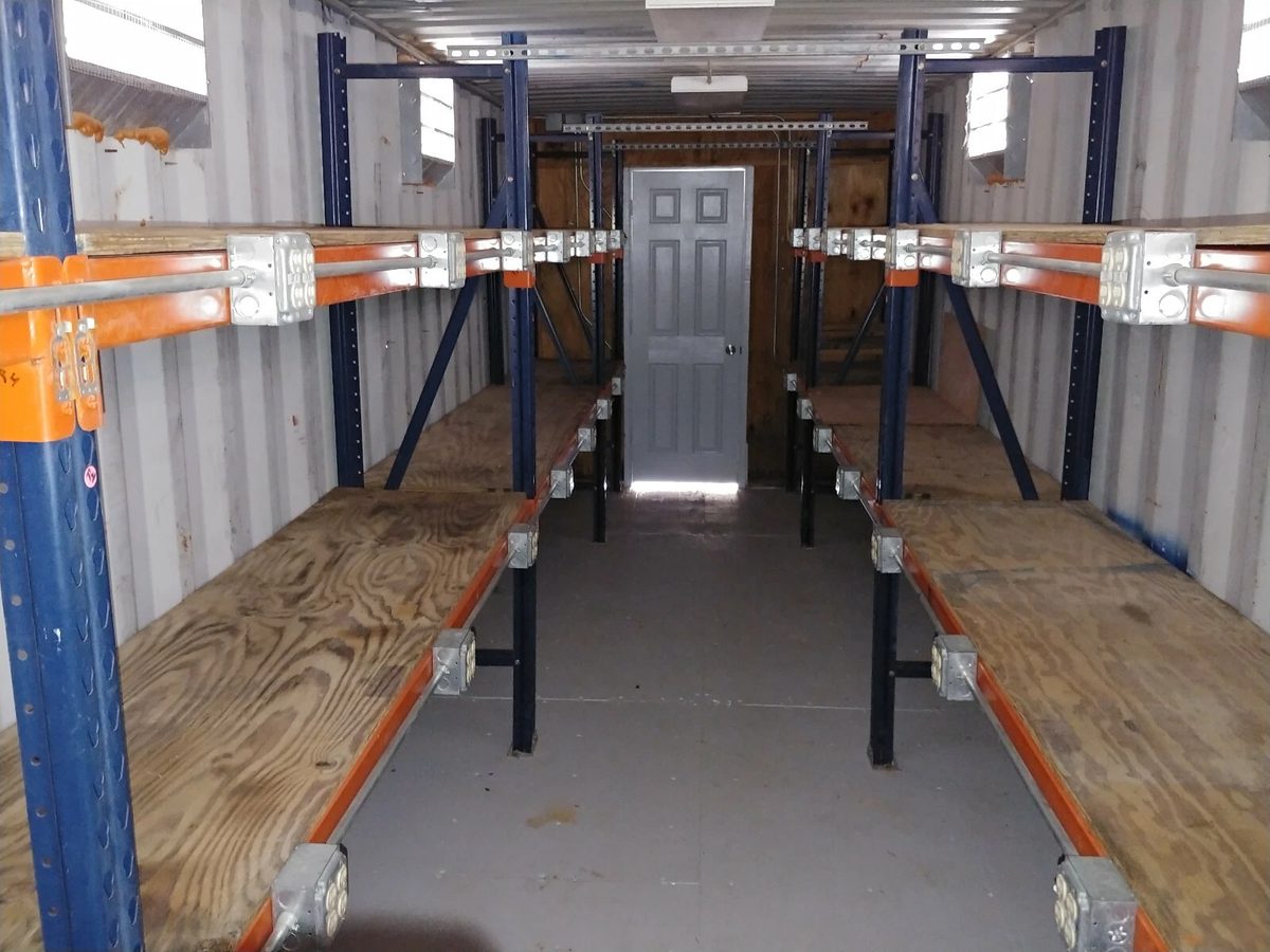 40ft High Cube Container Office – Storage Racking, Side Access – container storage interior with wooden shelving and rear door