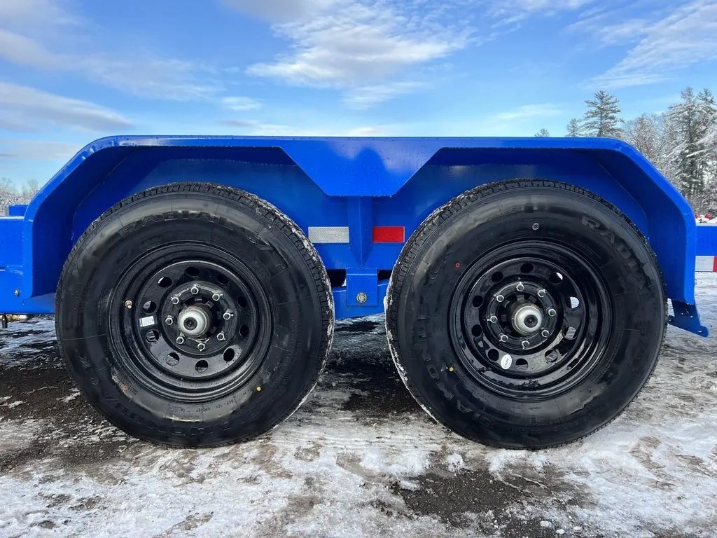 2024 Rice Trailers 20 ft Tilt Trailer – Spare Mount – Close-up side view of the dual axles, black wheels, and blue fender