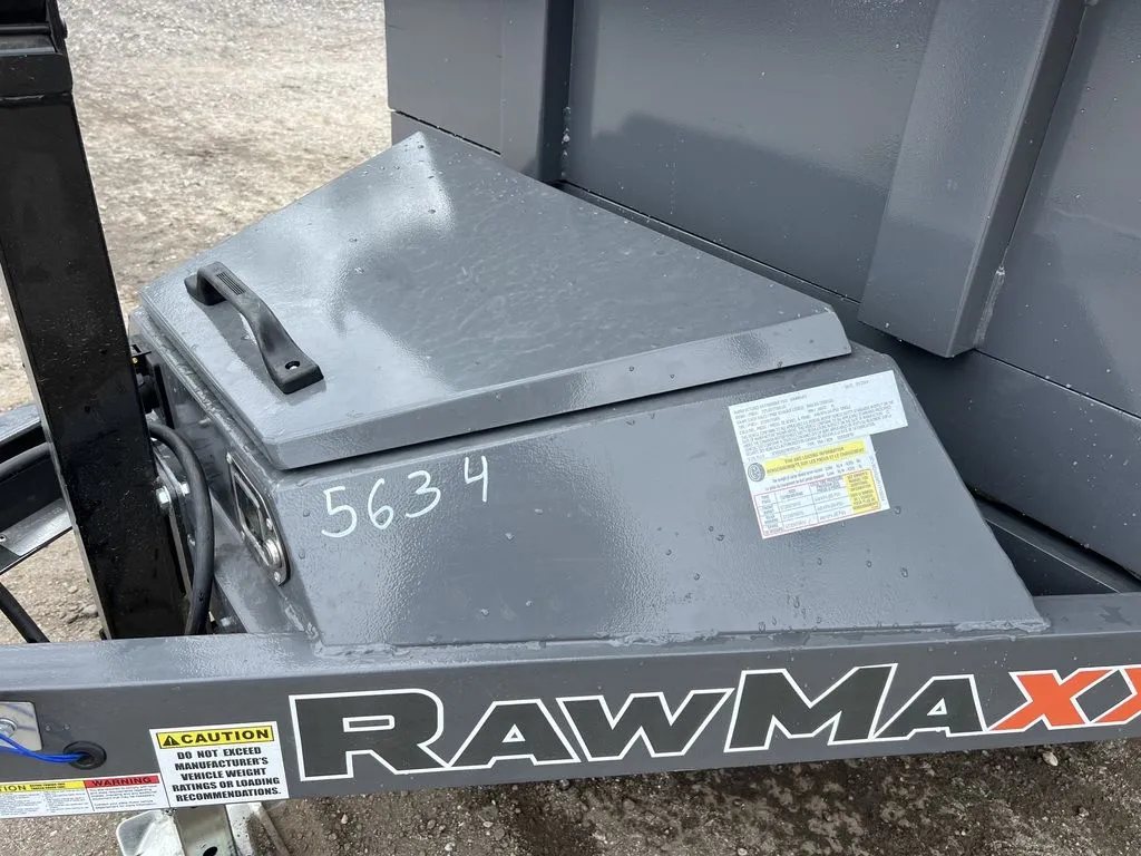 2024 RawMaxx 10 ft Dump Trailer – Shadow Grey – Close-up of the closed metal storage box on the trailer tongue with safety labels