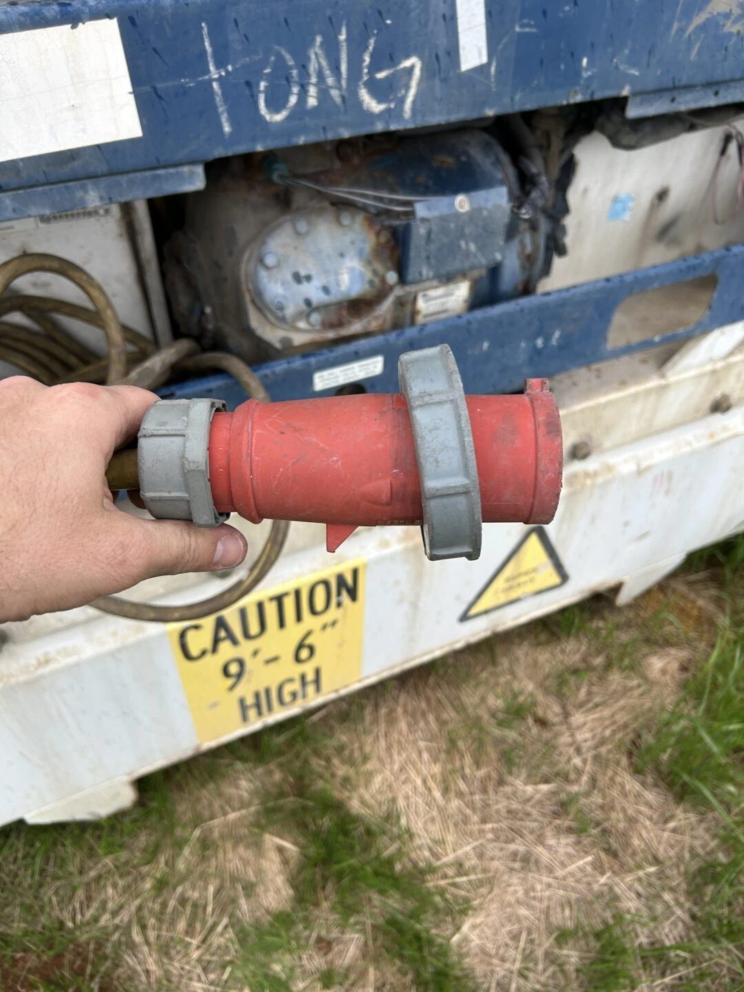 40ft High Cube Refrigerated Container – Insulated Storage – hand holding electrical connector beside exposed refrigeration machinery