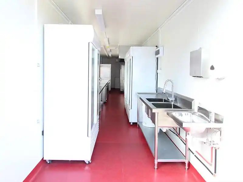 Shipping Container Kitchen – Insulated, Lockable – Interior corridor view showing commercial refrigeration units and prep sinks