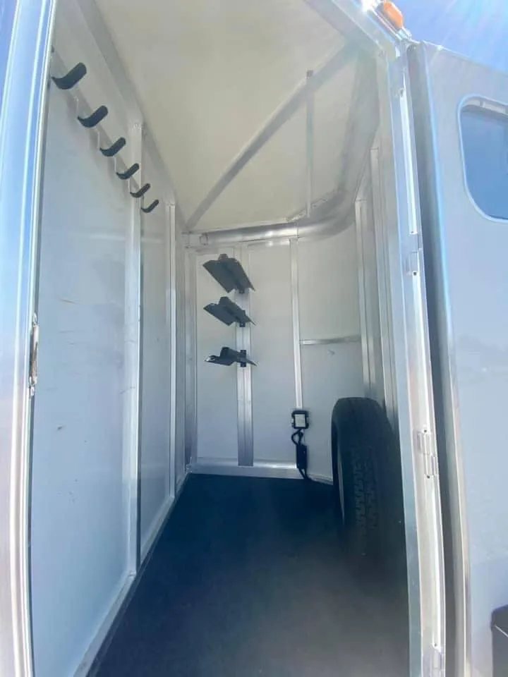 2011 Cimarron 3 Horse Bumper Pull – Insulated Roof – Front tack room interior showing spare tire and saddle racks