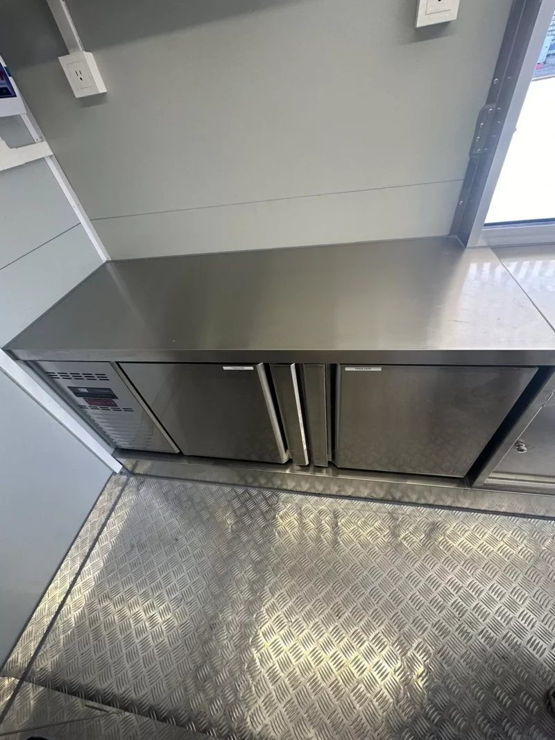 14 ft Food Trailer – Red Finish – Stainless steel under-counter refrigeration unit inside the food trailer