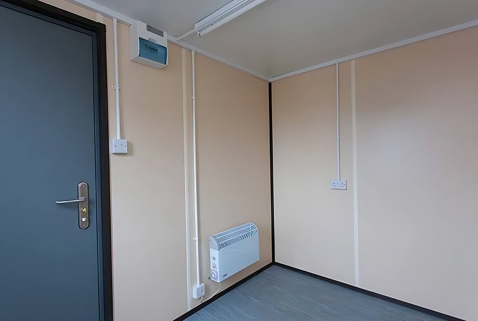20ft Steel Office Container – Open Workspace Shell – empty office interior with steel door and wall heater