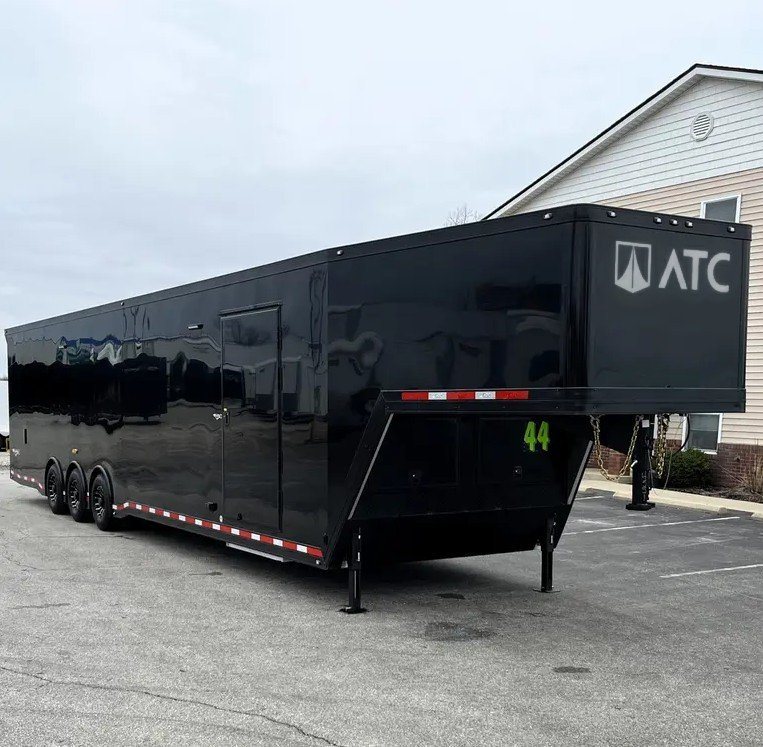 2025 ATC 44 ft Car Hauler – Premium Escape Door – Three-quarter front view of a black triple axle aluminum gooseneck trailer