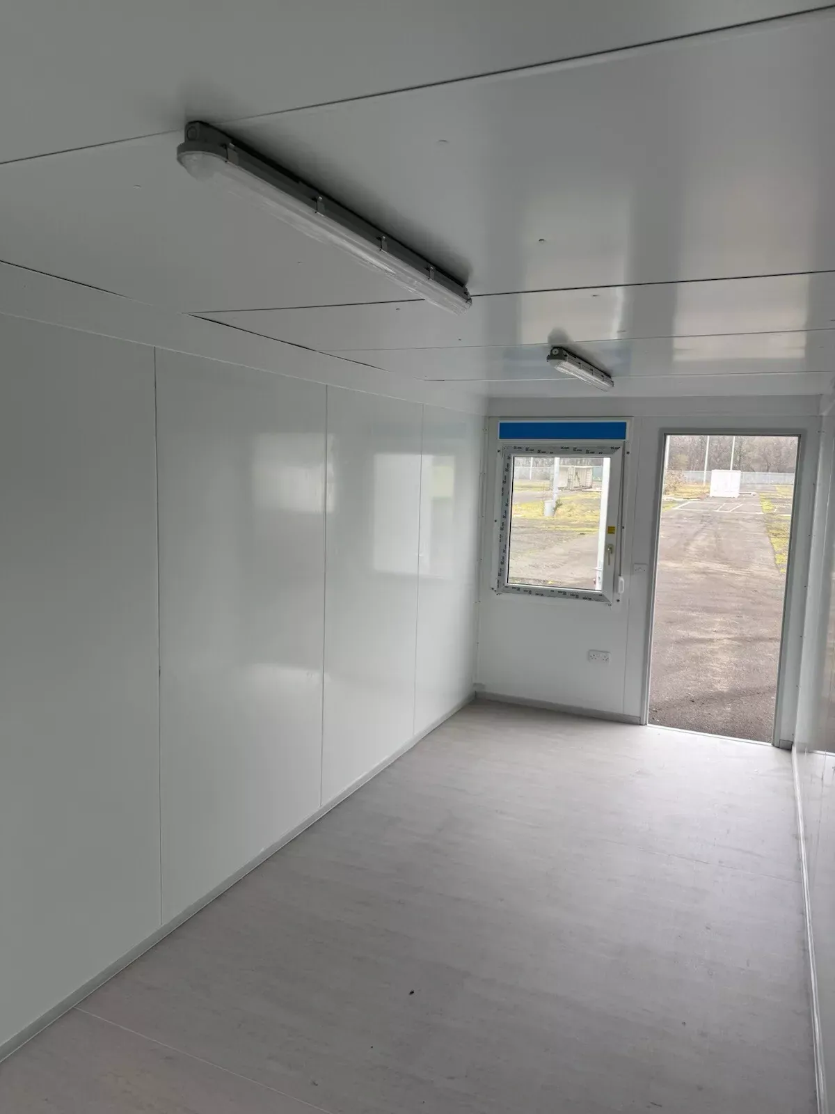 20ft Modular Container Office – Insulated Steel Workspace – empty office interior with white walls and glazed entry door