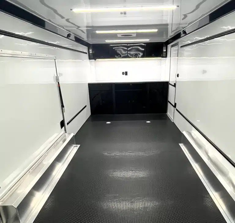 2026 ATC 24 ft Car Hauler – ROM 450, LifeTrac – Clean white interior of trailer with black cabinets and black coin flooring