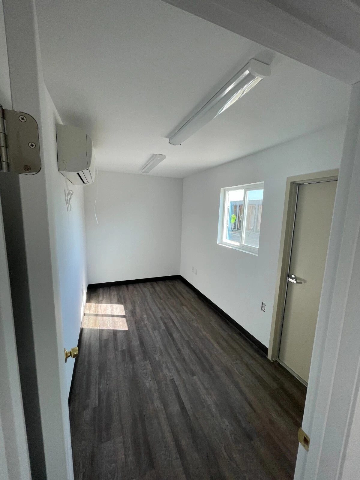 40ft Converted Container Office – Accessible Restroom – empty office with white walls and wood-look flooring