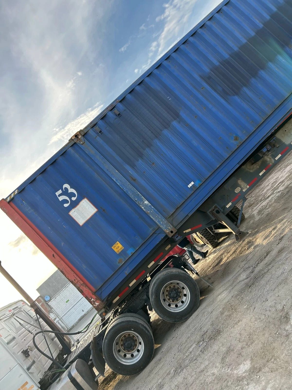 53ft High Cube Steel Shipping Container – Double End Doors – blue shipping container on truck trailer at steep angle