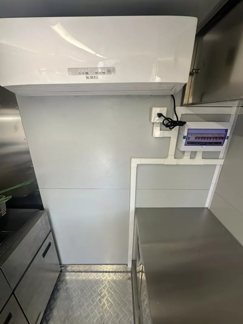 14 ft Food Trailer – Red Finish – Interior wall with a white air conditioning unit and electrical panel