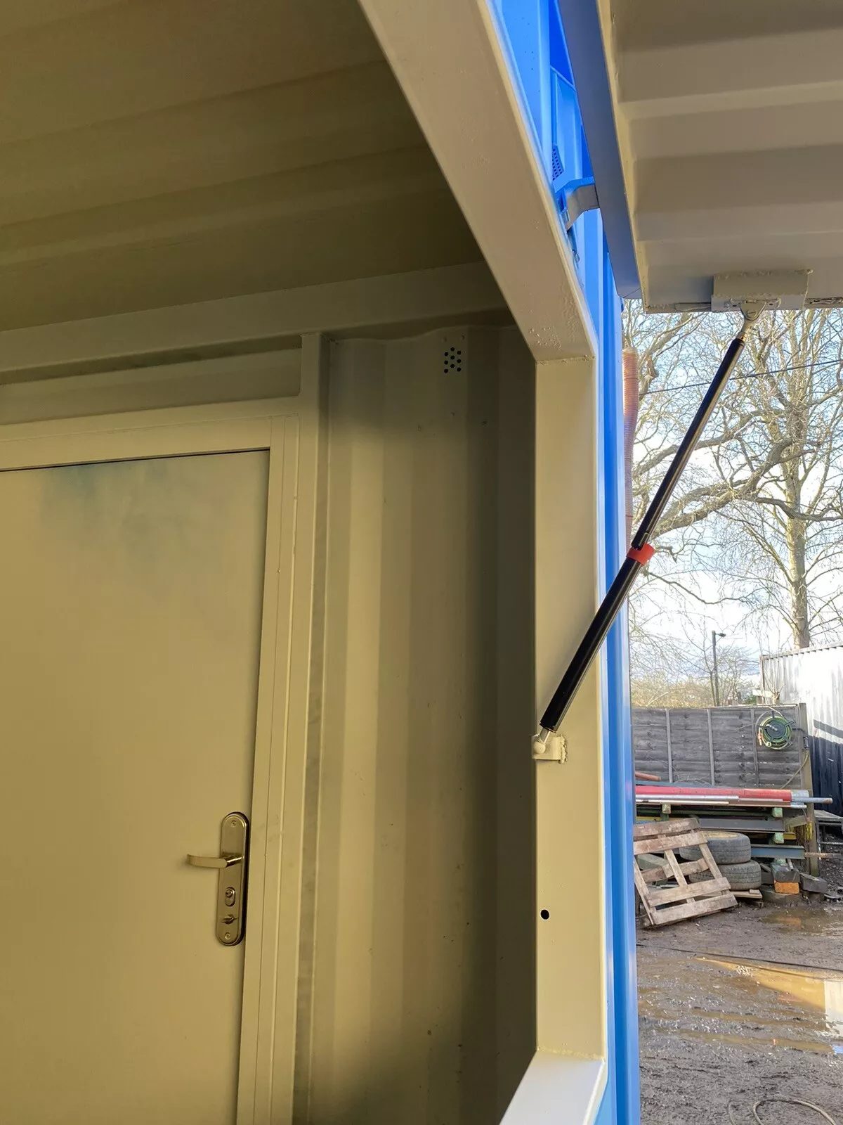 15ft Custom Container Bar & Kiosk – Side Service Hatches – close-up of service hatch support strut beside interior door