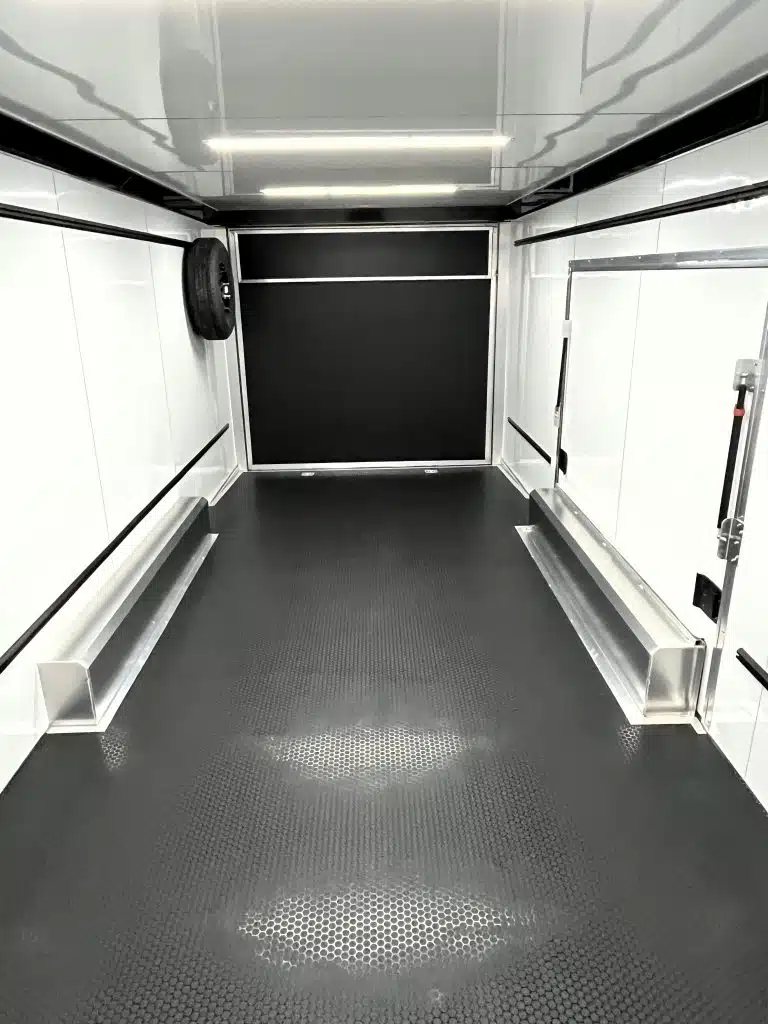 2025 ATC 24 ft Car Hauler – Large Escape Door – Interior rear view of the trailer showing empty cargo space and spare tire