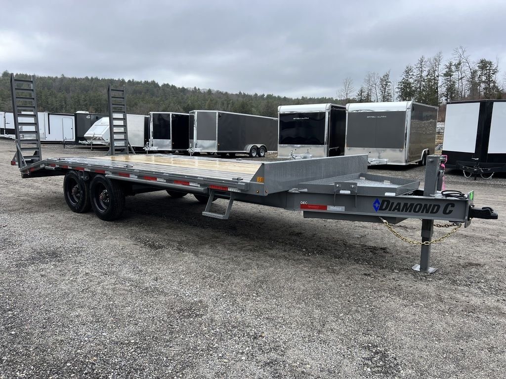 2024 Diamond C Deckover Equipment Trailer – Cement Gray – Front three-quarter view of a gray deckover equipment trailer with upright ramps