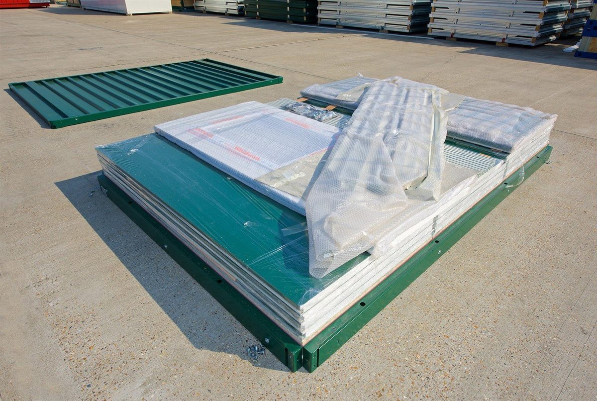 Flat Pack Office – Insulated Panels, Pre-Wired Electrical – stacked flat pack office panels and wrapped components outdoors