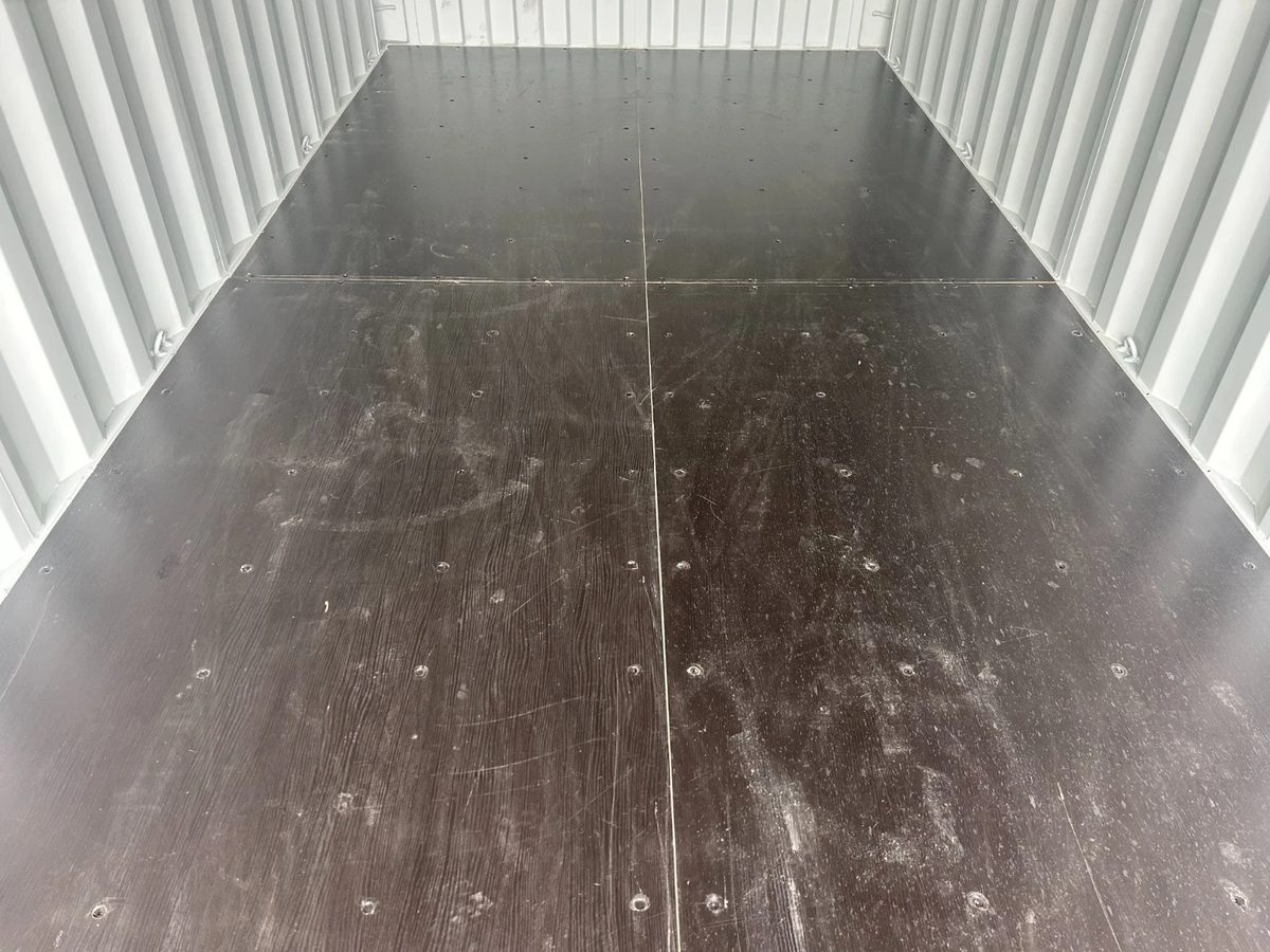 20ft New Shipping Container – One-Trip, Double Doors – empty container interior with dark plywood floor and corrugated walls