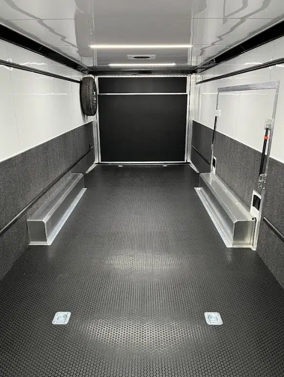 2026 ATC 28 ft Car Trailer – Premier Package – Interior view facing the rear ramp door with spare tire mounted