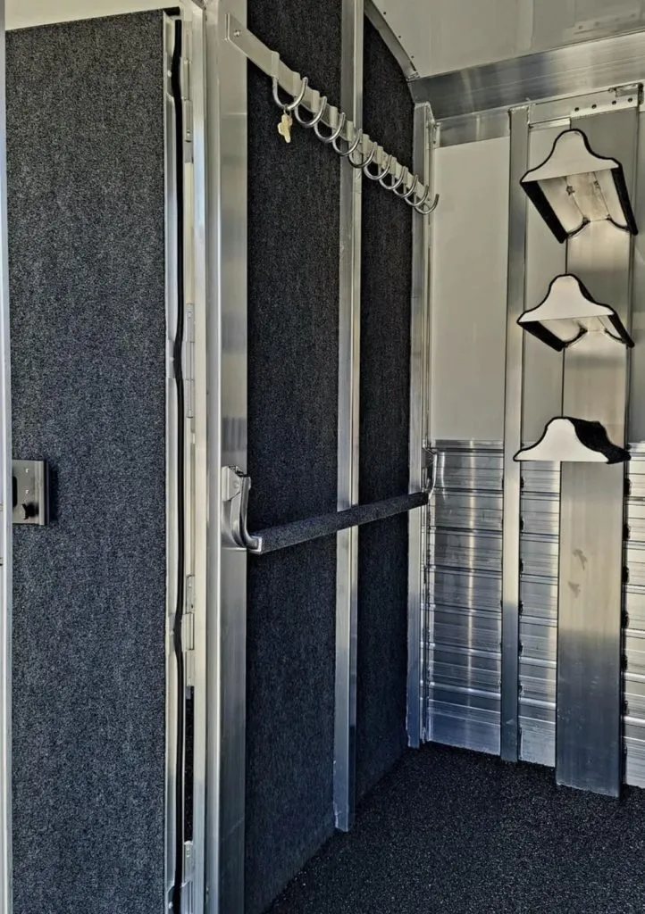 2023 4 Star 23 ft Horse Trailer – 2+1 Gooseneck – Tack room interior with carpeted walls and vertical saddle rack
