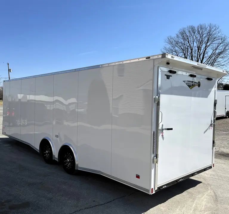 2025 Millennium Blaze 26 ft Car Hauler – Cabinets – Rear and side exterior view of the white trailer with ramp door closed