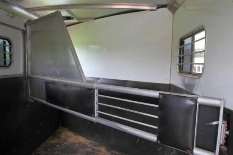 2003 Sundowner 2 Horse Trailer – Dressing Room – Padded horse divider inside the trailer with a window in the background