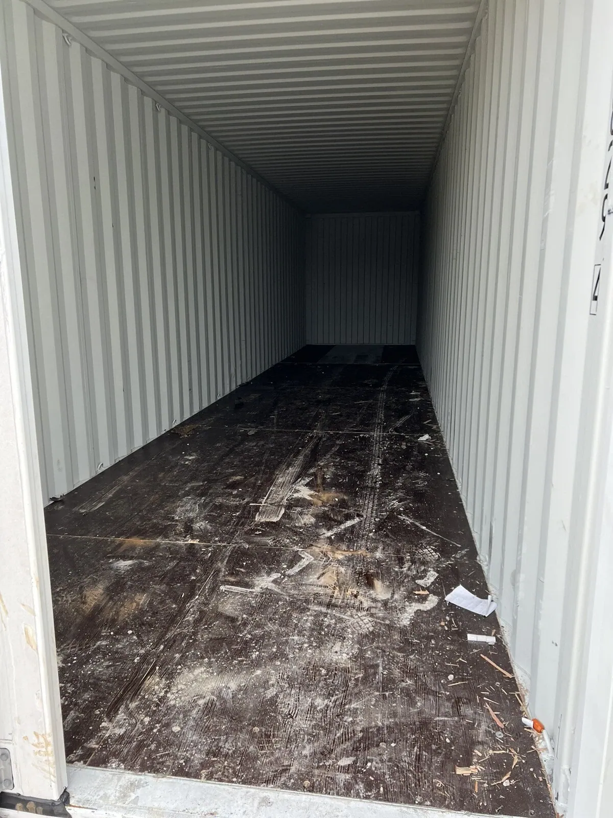 40ft High Cube Shipping Container – One-Trip, Double Doors – empty container interior with scuffed wooden floor and debris