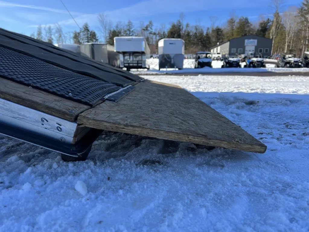 2008 Sno Pro 4-Place Snowmobile Trailer – Black Aluminum – Close-up side view of the edge of the wood ramp door