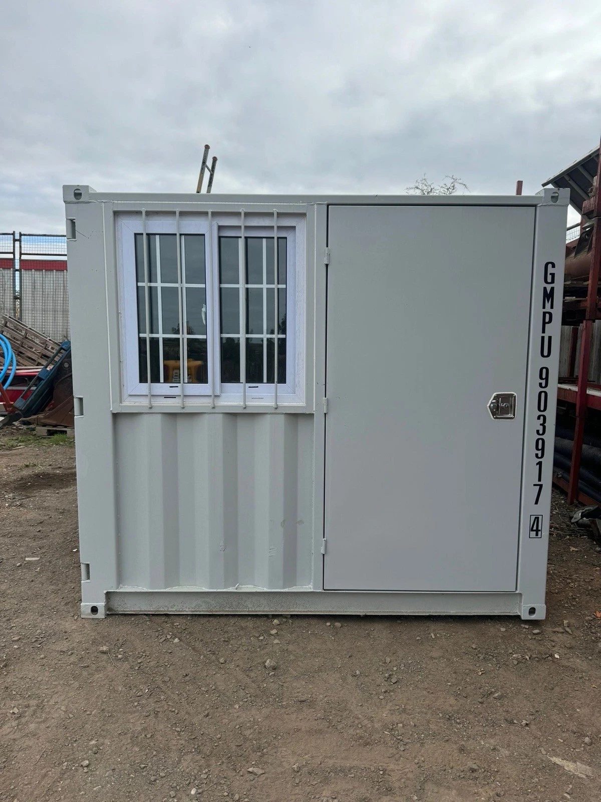7ft New Storage Container – Window and Personnel Door – front view of storage container with barred window and door