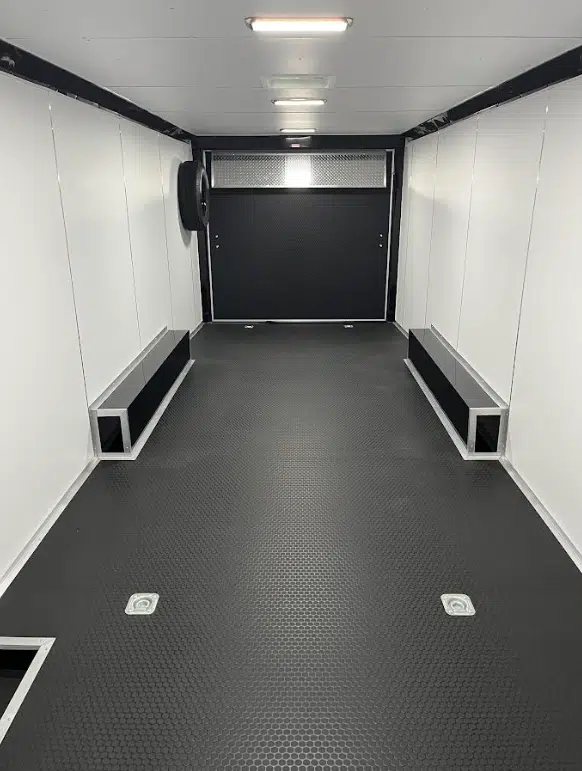 2025 Millennium 26 ft Car Hauler – Black-Out – Interior view of the trailer showing white walls, black rubber floor, and wheel wells
