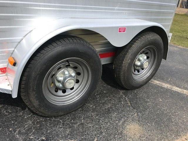 2010 Merhow 2 Horse Slant Trailer – Insulated Roof, Escape Door – Close-up view of the tandem axles, tires, and silver fenders