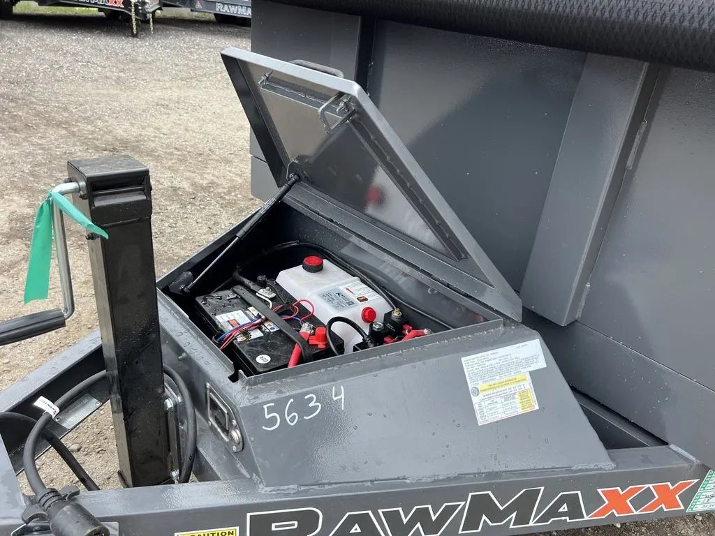 2024 RawMaxx 10 ft Dump Trailer – Shadow Grey – Open metal storage box on the trailer tongue showing the battery and hydraulics
