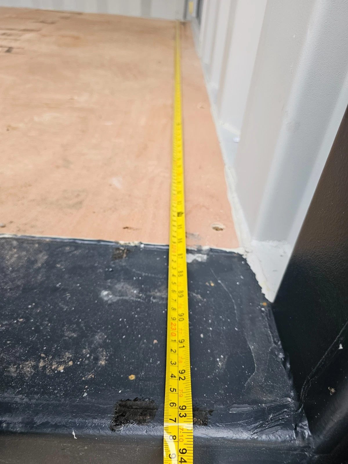 8ft New Shipping Container – Lockbox and Barred Windows – Tape measure along container floor and doorway threshold