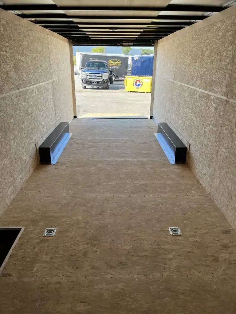 2026 Millennium 24 ft Car Hauler – Black Hero – Interior of the trailer looking out towards the open rear ramp door showing floor tie-downs