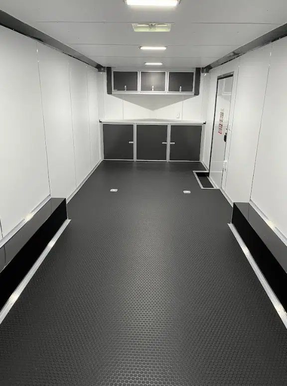 2025 Millennium 26 ft Car Hauler – Charcoal – Finished interior view looking toward the front cabinets with white walls and black floor