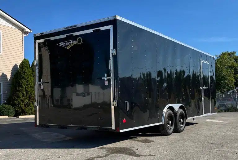 2026 Millennium 24 ft Car Hauler – Black Hero – Rear three-quarter view of the black enclosed trailer showing the rear ramp door and side
