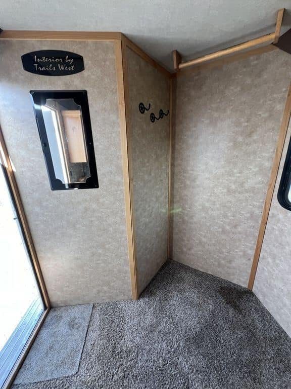 2020 Trails West Sierra 4 Horse Gooseneck – Comfort Package – Carpeted dressing area with wooden trim and hanging clothes rod