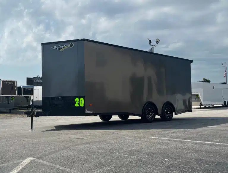 2025 Millennium 20 ft Car Hauler – Black-Out Package – Exterior three-quarter view of a charcoal gray enclosed trailer with black trim and wheels