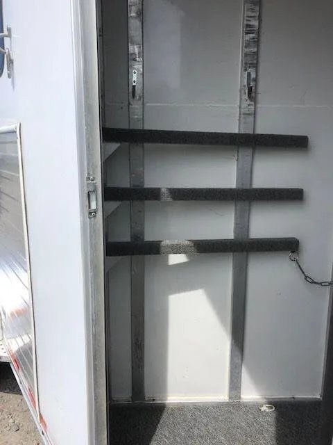 2010 Merhow 3 Horse Bumper Pull Trailer – Rear Ramp – Interior view of the tack room showing bridle hooks and saddle rack