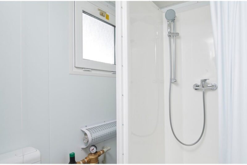 Mains Toilet/Shower Cabin – Green Galvanized Steel – Interior view showing the shower cubicle with adjustable head and a small window