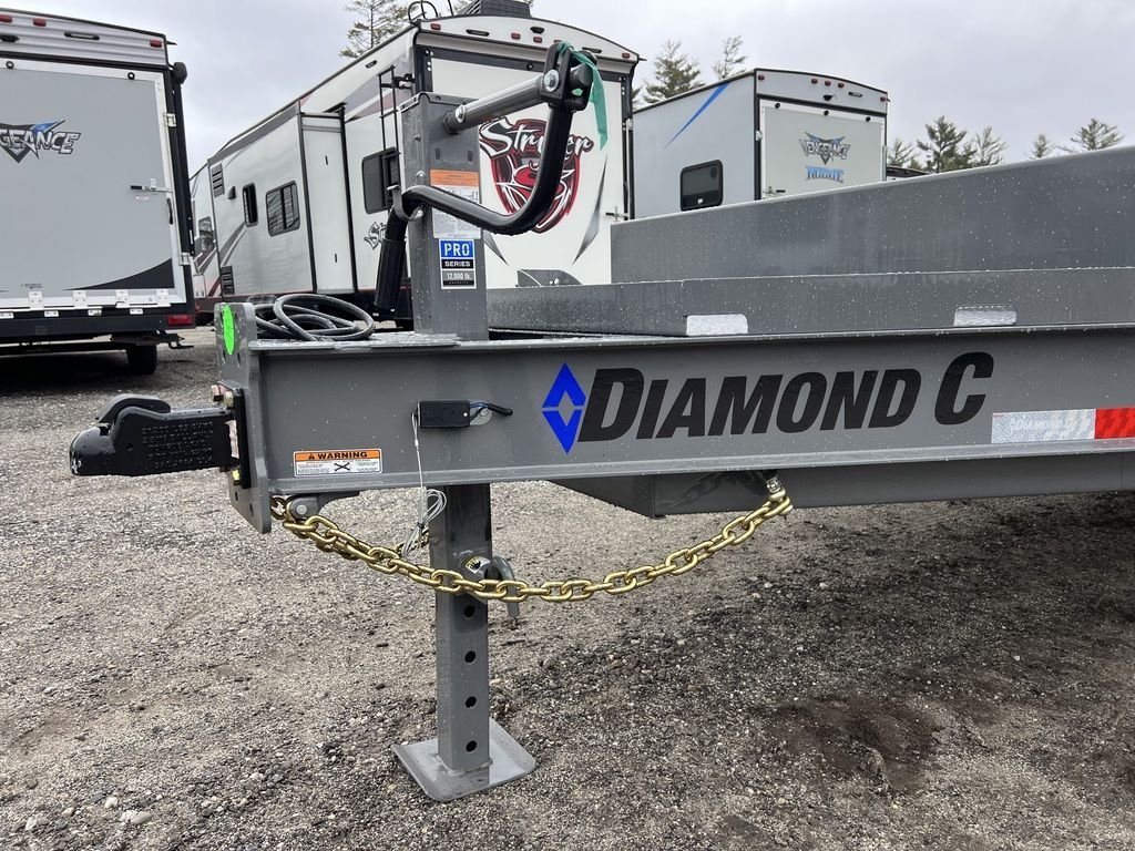 2024 Diamond C Deckover Equipment Trailer – Cement Gray – Close-up view of the trailer hitch assembly and leveling jack