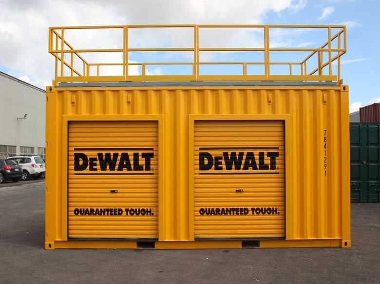 Trade Show Display Container – Lockable Steel Booth – Straight on side view of the yellow container with two closed roller doors