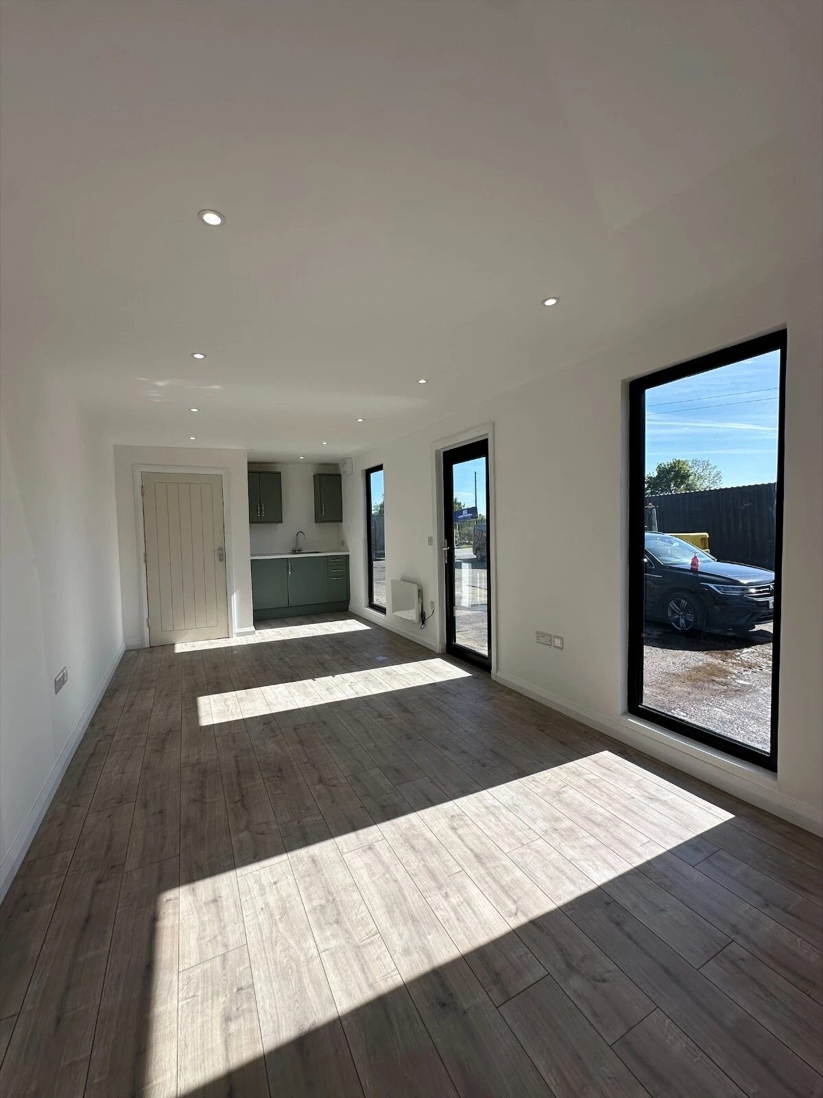7.5m Modular Office – Kitchenette and Private Bathroom – Empty office interior with kitchenette and tall windows