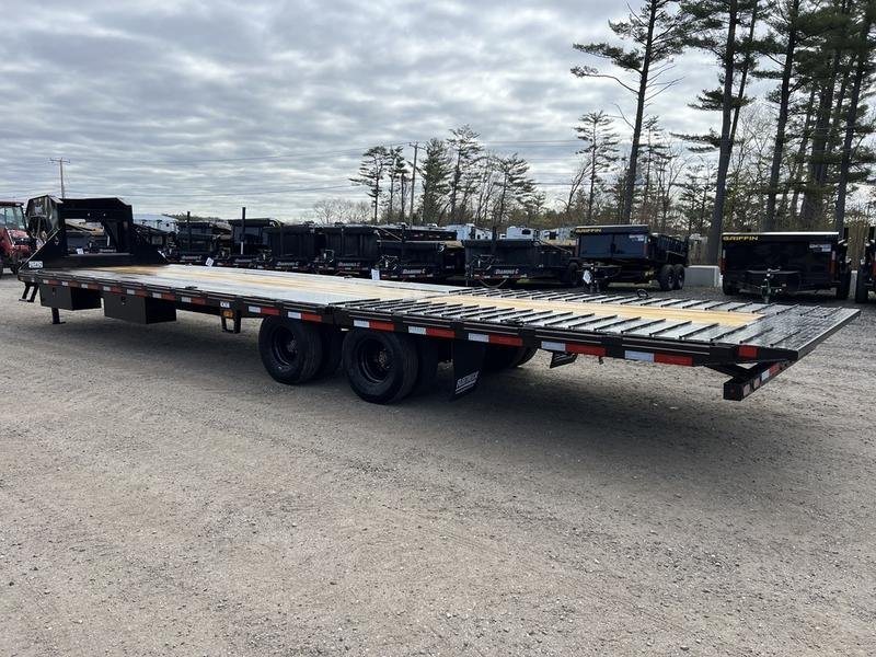 2024 Diamond C 35 ft Equipment Trailer – Auto Dovetail – A rear-angle view of a long black equipment trailer with a wood deck