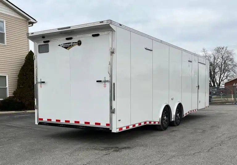 2026 Millennium Extreme 28 ft Enclosed Car Hauler – White – Rear three-quarter view of a white enclosed trailer with closed ramp door