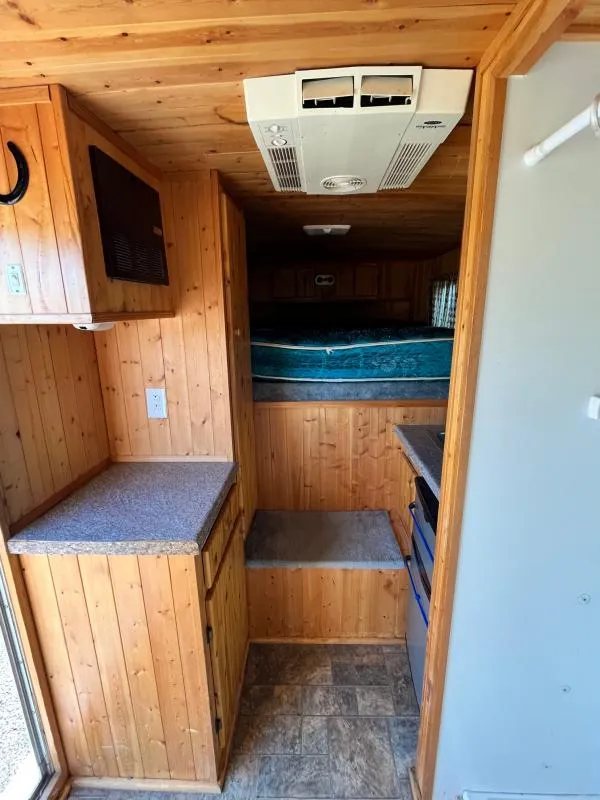 2004 Sundowner 3 Horse Trailer – Weekender Living Quarters – Wide view of the wood-paneled living quarters showing the AC unit on the ceiling