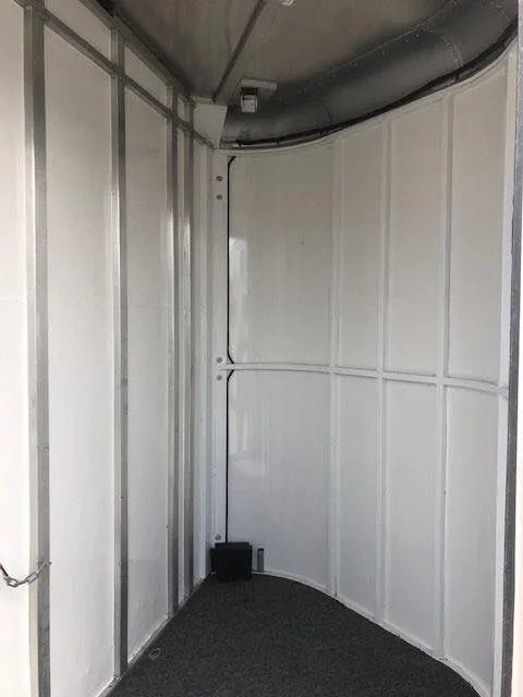 2010 Merhow 3 Horse Bumper Pull Trailer – Rear Ramp – Clean empty corner of the dressing room with white paneled walls