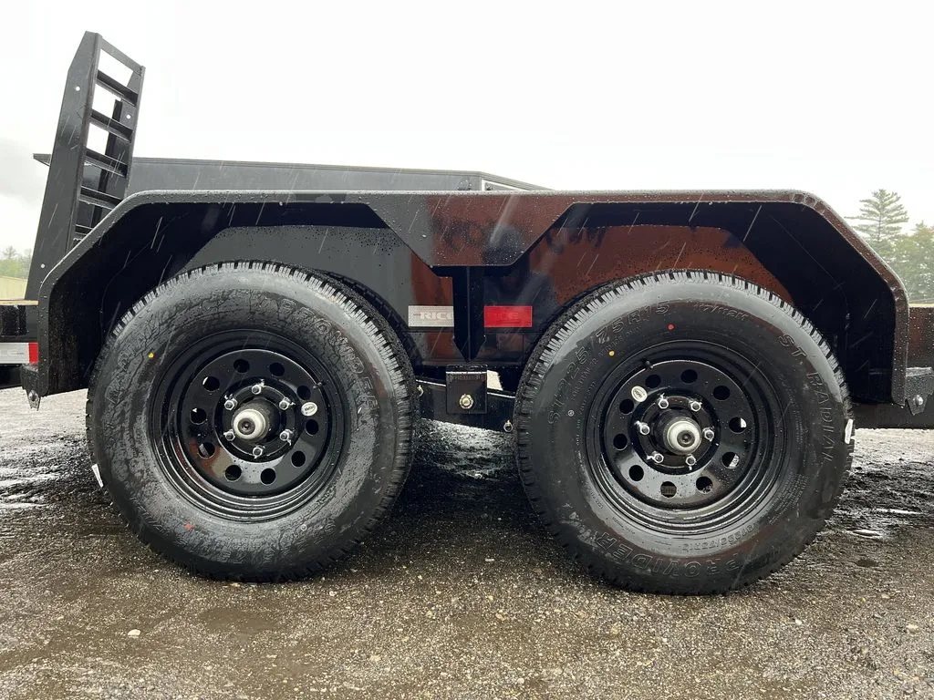2024 Rice Trailers 16 ft Equipment Trailer – Toolbox – Close-up of the dual axles and black wheels under the trailer fender