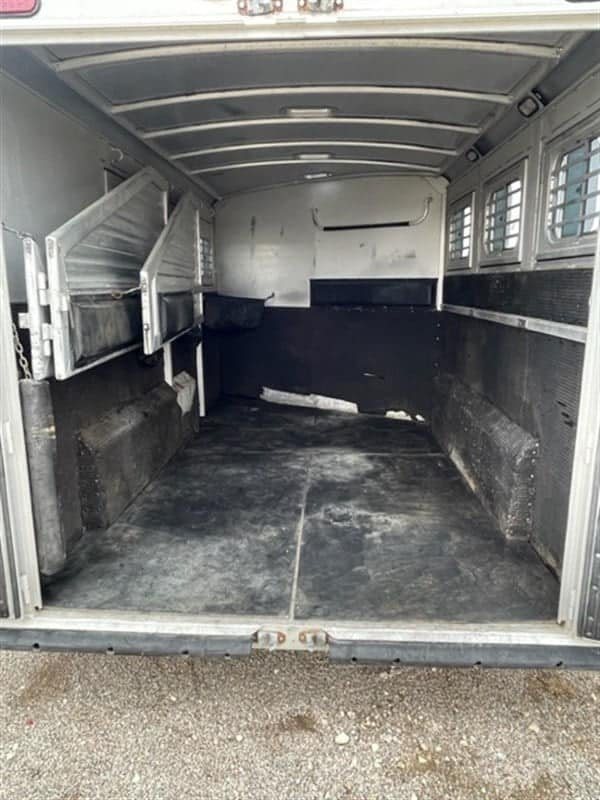 1999 Elite Custom 3 Horse Trailer – Rotating Saddle Rack – View looking into the horse stalls with rubber mat flooring and dividers