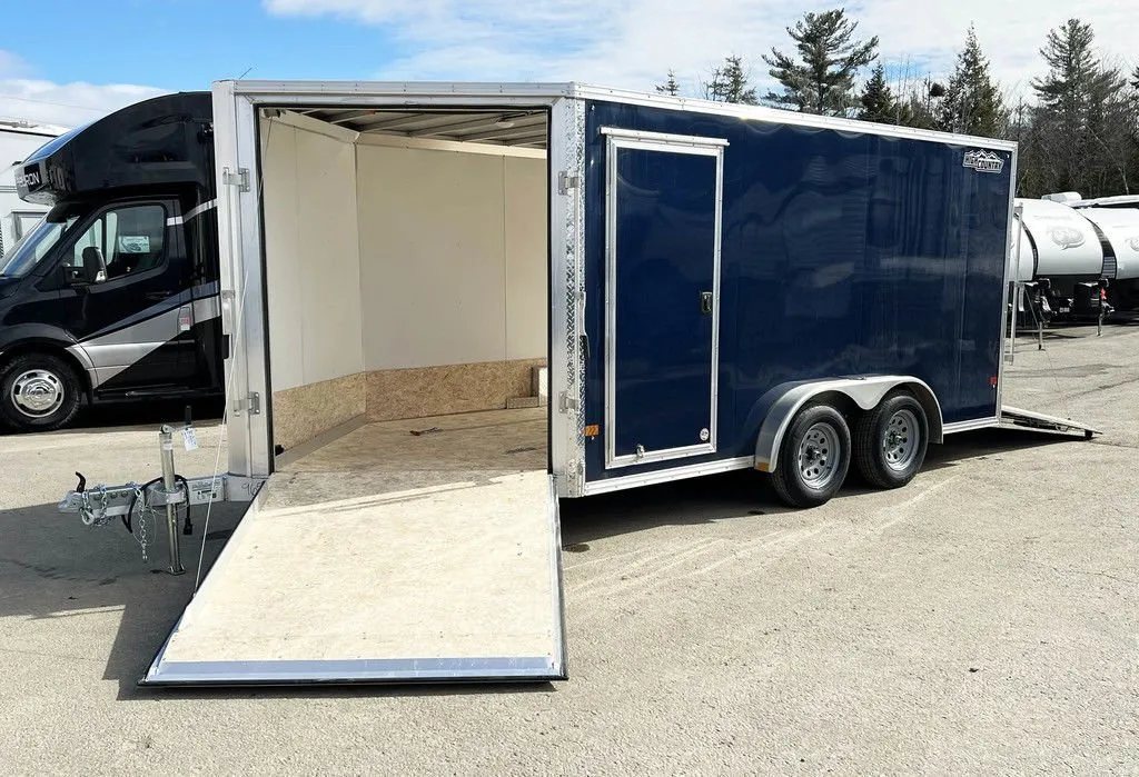2023 High Country 14 ft Trailer – Blue, Drive-Through – The front ramp door lowered to the ground showing the wooden interior floor
