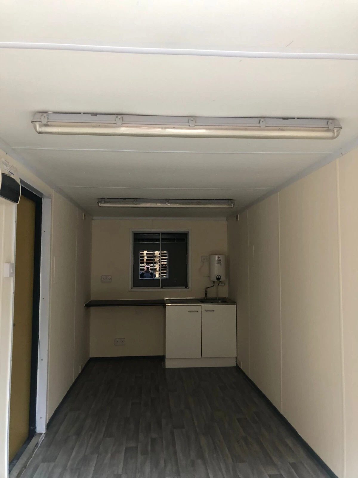 20ft Anti-Vandal Office Canteen – Insulated Steel Workspace – Empty canteen interior with sink, cabinets and wall mounted water heater