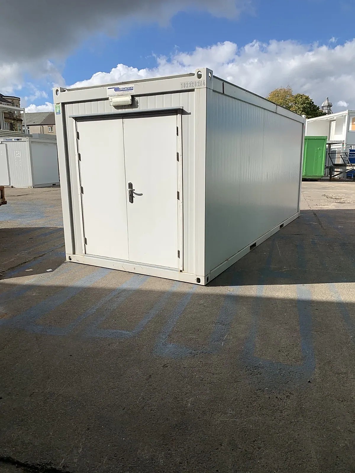 20ft Insulated Storage Container – Steel Lock Boxes – White storage container with closed double doors and exterior light in a paved yard