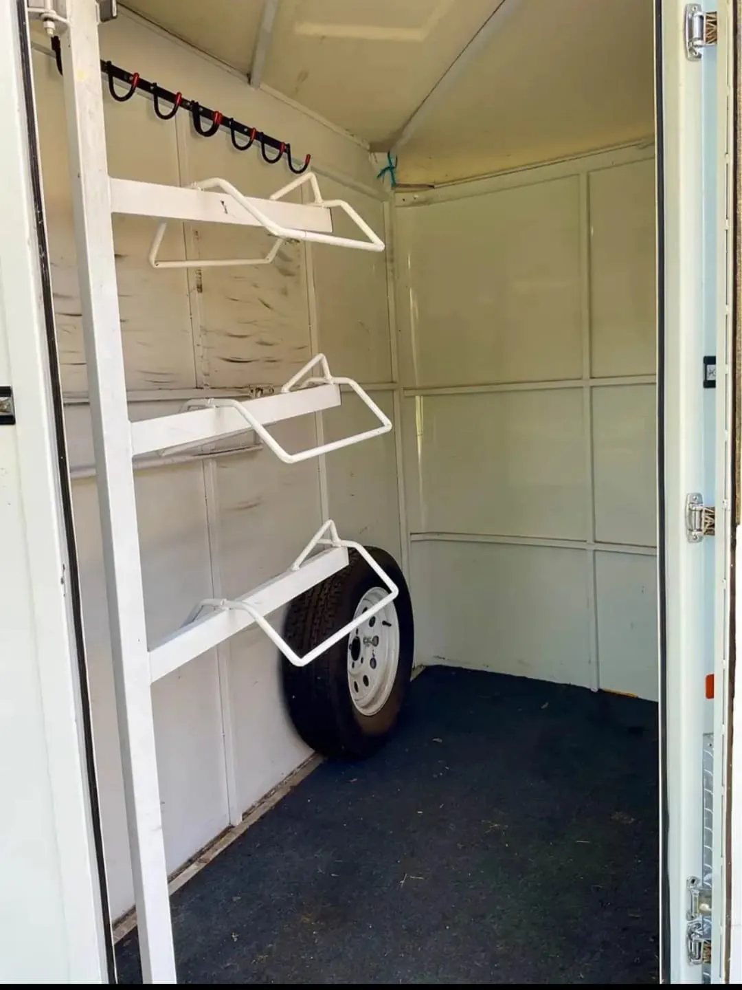 2007 Circle J 2 Horse Trailer – Slant Load – Interior of front tack room showing saddle racks and spare tire